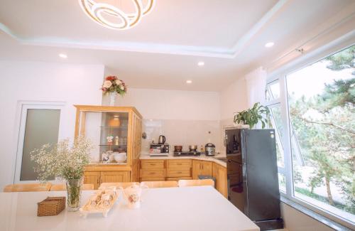 a kitchen with a refrigerator and a table in it at Villa Đà Lạt View Thông in Khu Chi Lăng
