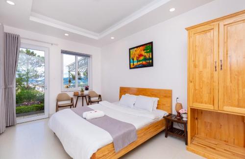 a bedroom with a large bed and a window at Villa Đà Lạt View Thông in Khu Chi Lăng