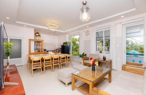a living room with a table and a dining room at Villa Đà Lạt View Thông in Khu Chi Lăng