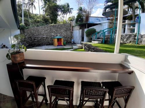 une terrasse couverte avec des chaises, une table et un mur en pierre dans l'établissement Seaview Hill (Family room with private Pool), 