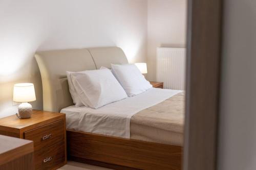 a bedroom with a bed with white sheets and pillows at The Archanes Sapphire in Archanes