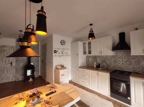 una cucina con lampadari a pendente neri e un tavolo di GuestHouse III a Lesko
