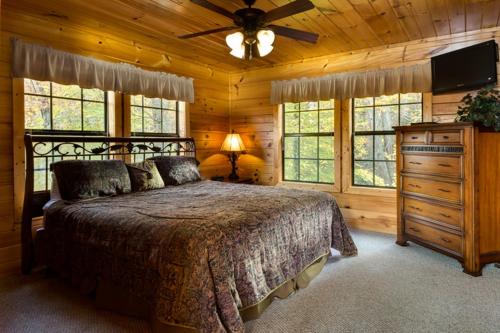 una camera con letto e ventilatore a soffitto di Away From it All, 3 Bedrooms, Sleeps 10, Jetted Showers, WiFi, Arcade a Gatlinburg