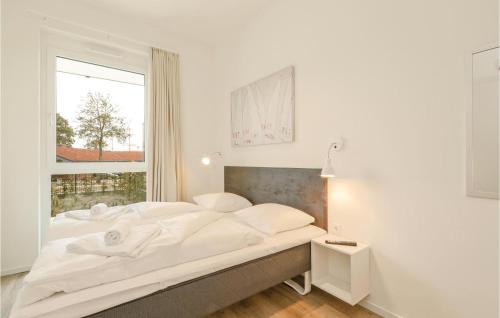 トラフェミュンデにあるPet Friendly Apartment In Lbeck Travemnde With Kitchenの白いベッドルーム(大型ベッド1台、窓付)