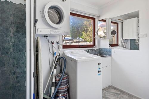 a laundry room with a washing machine and a sink at Beilby Beach Cottage - Free WiFi & Foxtel - Pet Friendly Outside Only in Inverloch