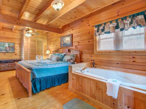 Dormitorio en cabaña de madera con cama y bañera en Dew South, 2 Bedrooms, Sleeps 8, Views, Arcade, Hot Tub, Pet Friendly, en Gatlinburg