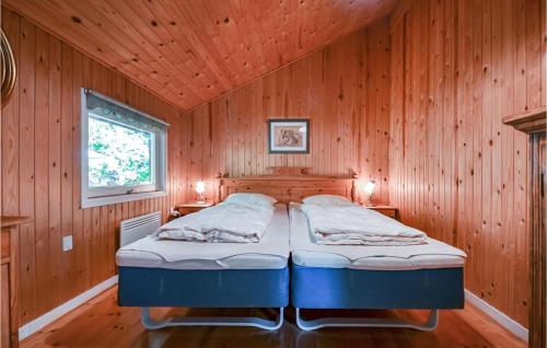 エーベルトフトにあるStunning Home In Ebeltoft With 1 Bedroomsの木造キャビン内のベッドルーム1室(ベッド2台付)