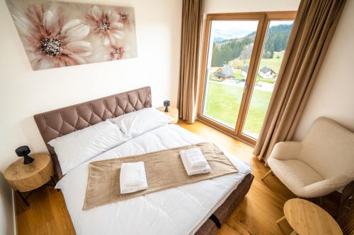 a bedroom with a bed and a chair and a window at Family apartment Kubínska Hoľa in Dolný Kubín