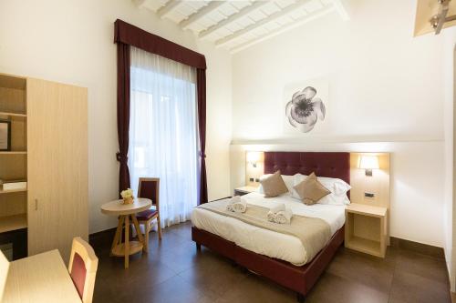 um quarto de hotel com uma cama, uma mesa e uma janela em SuitInn19 em Roma