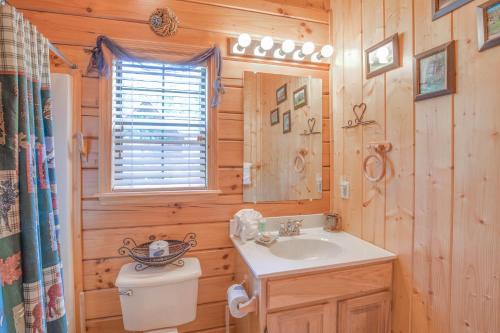 a bathroom with a sink and a toilet in a log cabin at Bear Escape, 1 Bedroom, Sleeps 4, Hot Tub, Pool Table, Jacuzzi Tub in Sevierville