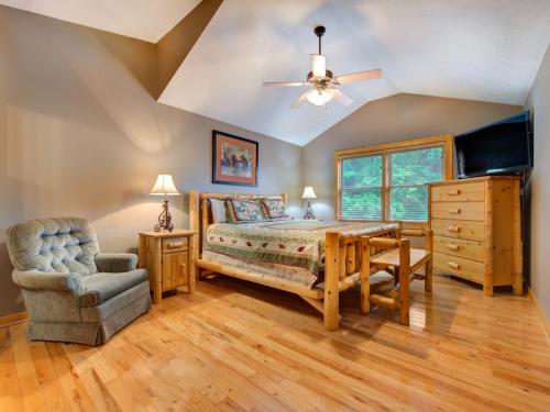 a bedroom with a bed and a table and a chair at Bear’s Corner, 3 Bedrooms, WiFi, Pool Table, Hot Tub, WiFi, Sleeps 10 in Gatlinburg