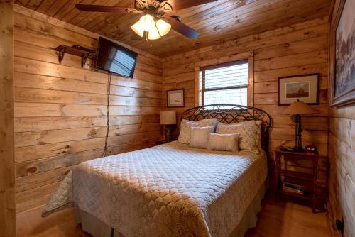 a bedroom with a bed and a ceiling fan at Rocky Top Lodge, 6 Bedrooms, Pool Access, Hot Tub, Mountain View, Sleeps 14 in Gatlinburg
