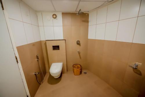 a small bathroom with a toilet and a sink at Hotel Heraa International in Mangalore