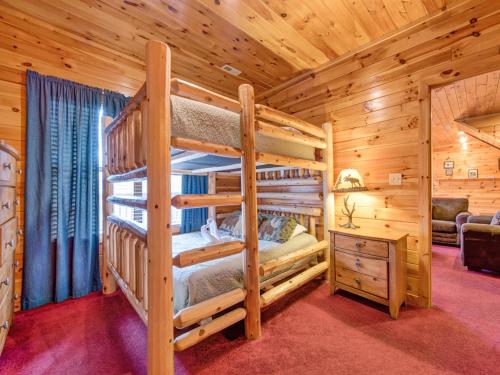 1 dormitorio con 2 literas en una cabaña de madera en Apple Bear Lodge, 4 Bedrooms, Sleeps 18, Jacuzzis, Pool Table, Hot Tub en Gatlinburg