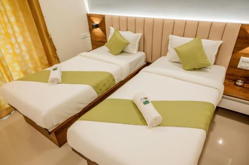 a hotel room with two beds and two seats at Hotel Heraa International in Mangalore