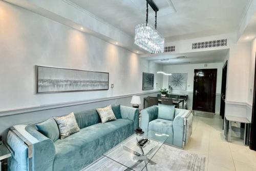 a living room with a blue couch and two chairs at Lux Burj views -Boulevard -Prime Location Downtown DUBAI in Dubai