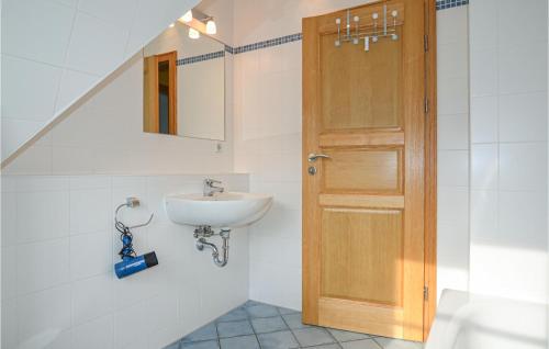 ein Badezimmer mit einem Waschbecken und einer Holztür in der Unterkunft Ferienhaus Wendisch-Rietz Seeadler, Luisenaue in Wendisch Rietz