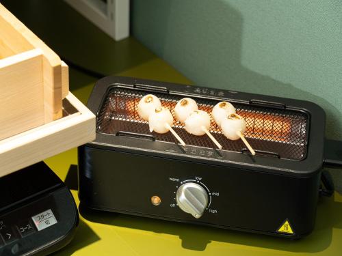 a toaster oven with four marshmallows at Vessel Inn Takadanobaba Station in Tokyo