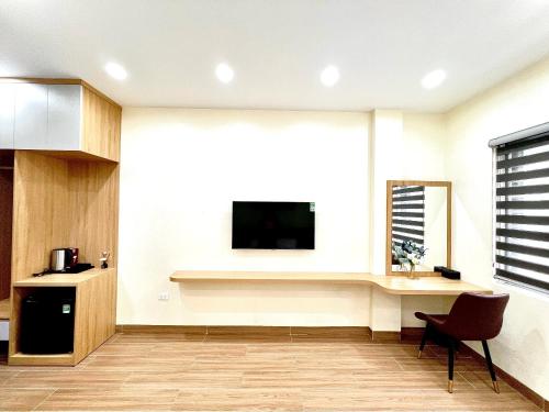 uma sala de estar com uma televisão na parede em Orion Hotel Halong em Ha Long