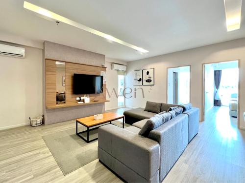 a living room with a couch and a tv at KWEN Suites-Tanjung Aru InfinityPool Seaview/Airport View in Kota Kinabalu