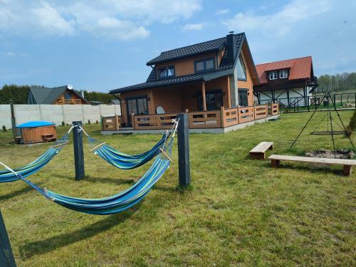 a house with two hammocks in front of a house at Kamyczek in Stare Juchy