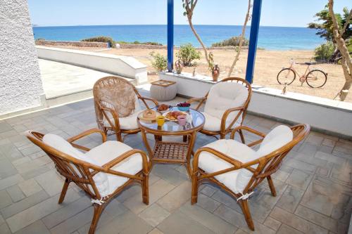 a patio with a table and chairs and the beach at Aroura Homes 4BR Beachfront Villa in Spetses