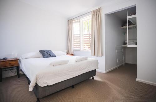 a bedroom with a large bed with a window at Mounties @ Sussex in Sussex inlet