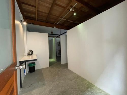 a hallway with a white wall and a wooden ceiling at Pranee Bungalow in Ko Tao