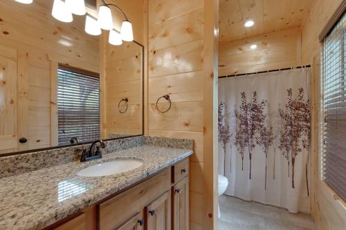 La salle de bains est pourvue d'un lavabo et d'une douche dans une cabine. dans l'établissement Smoky Mountain Splash, 6 Bedroom, Private Pool, WiFi, Pool Table, Sleeps 18, à Gatlinburg