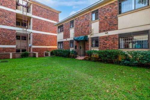 an empty yard in front of a brick building at Victoria Breeze Suites, Entebbe in Entebbe