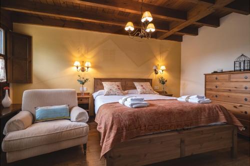 1 dormitorio con 1 cama grande y 1 silla en La Coqueta Del Sueve, en Arriondas
