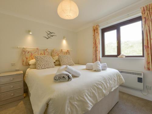 una camera da letto con un grande letto con asciugamani di 13 Burgh Island Causeway a Bigbury-on-Sea