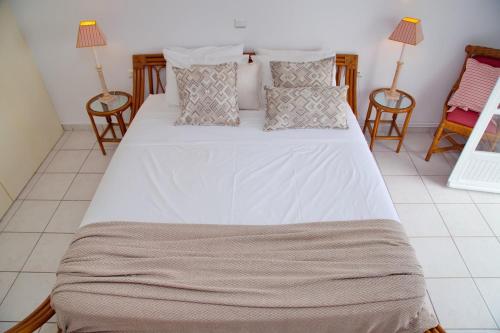 a large bed in a room with two chairs at Aroura Homes 4BR Beachfront Villa in Spetses