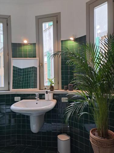 La salle de bains est pourvue d'un lavabo et d'un mur carrelé vert. dans l'établissement Pontida 27, à Bergame