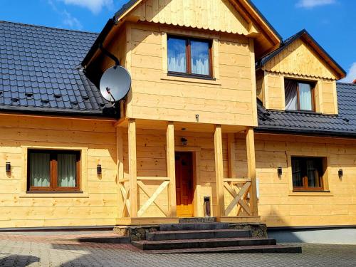 een houten huis met een deur en een veranda bij Domek w Górach in Korbielów