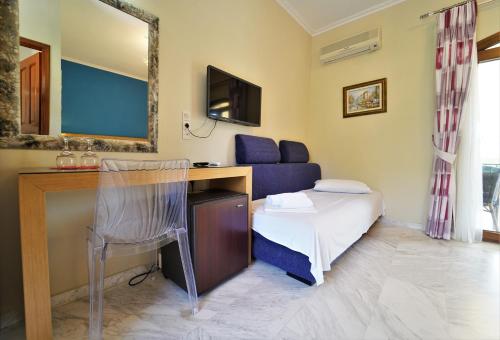 a room with a bed and a desk with a chair at Villa Ilias in Parga