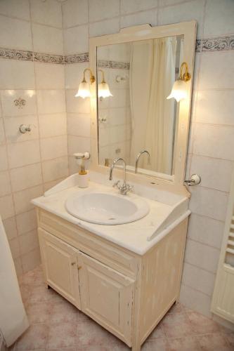 a bathroom with a white sink and a mirror at Aroura Homes 4BR Beachfront Villa in Spetses