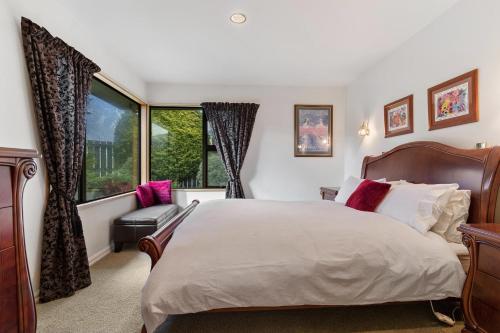 a bedroom with a large bed and a window at Charming house with lovely views in Queenstown