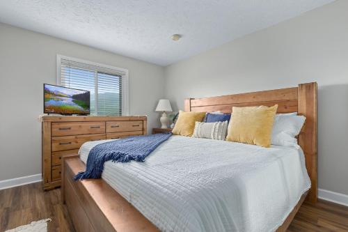 Schlafzimmer mit einem großen Bett mit einem Kopfteil aus Holz in der Unterkunft Deer Ridge Mountain Resort A201 in Gatlinburg