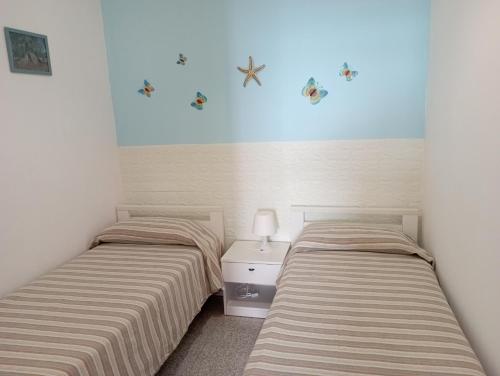 - deux lits assis l'un à côté de l'autre dans une pièce dans l'établissement Casa al mare Ostuni camerini, à Villanova di Ostuni