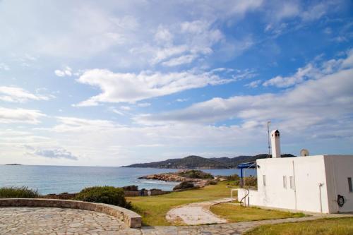 um edifício branco ao lado de uma massa de água em Aroura Homes 4BR Beachfront Villa em Spetses