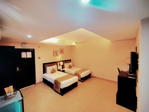 ハイデラバードにあるSWAGATH DE ROYAL HOTELのベッド2台、薄型テレビが備わるホテルルームです。