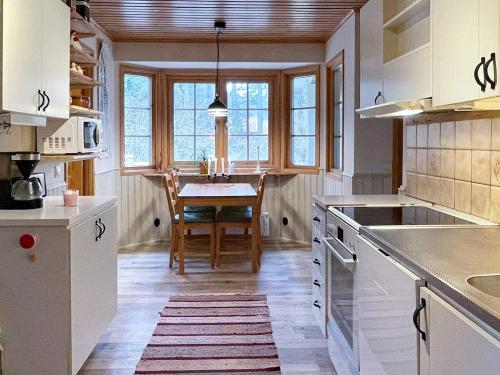 uma cozinha com armários brancos e uma mesa em Holiday home YNGSJÖ III em Yngsjö