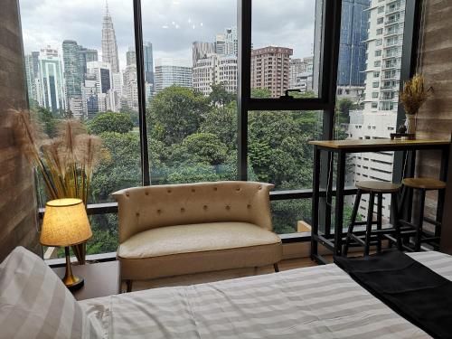 a bedroom with a chair and a large window at Romantic Log Cabin - walk to KL Tower, KLCC, Bukit Bintang in Kuala Lumpur