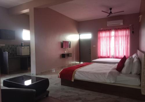 a bedroom with a large bed with a red window at Hotel Golden Heights Gokarna in Gokarna
