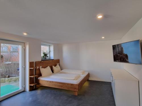 a bedroom with a bed and a large window at Urlaubsreiterhof Trunk in Igersheim