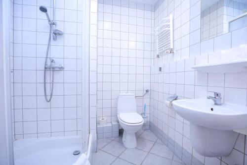 Bielik Apartament B12 SPA i Wellness z Balkonem blisko plaży في مينززدرويه: حمام ابيض مع مرحاض ومغسلة