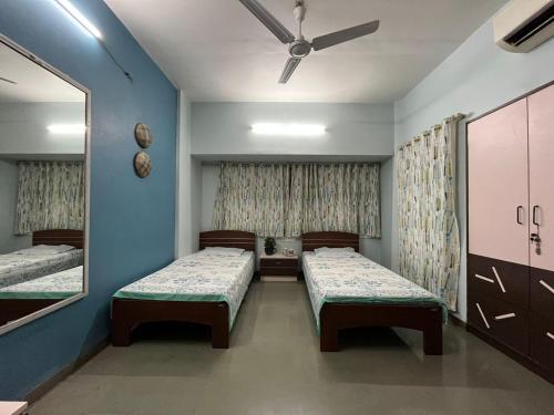 a hospital room with two beds and a mirror at Tripvana Apartment in Nashik