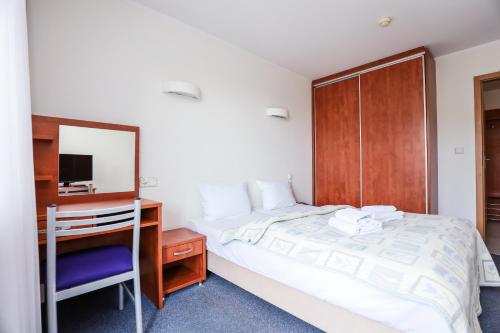 1 dormitorio con cama, escritorio y espejo en Bielik Apartament B12 SPA i Wellness z Balkonem blisko plaży, en Międzyzdroje
