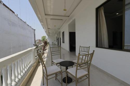 a balcony with chairs and a table and a window at The White Lotus in Gaya